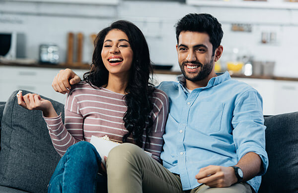 Latino-couple-on-couch latino couple watching TV