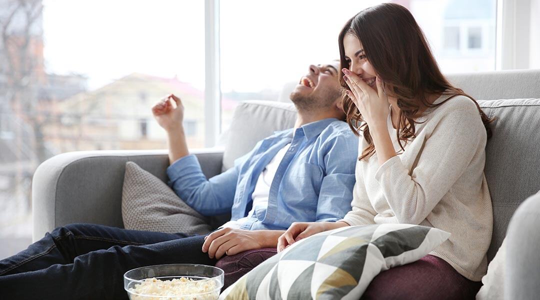 Couple laughing while watching DIRECTV STREAM
