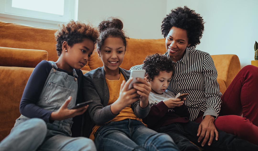Madre e hijos mirando los smartphones