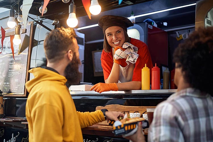 Food truck owner talking to customers